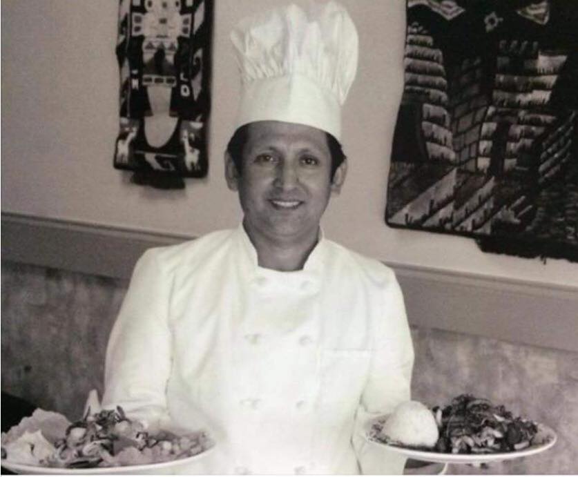 Archival black-and-white photograph of the chef and owner of Ceviche 595 holding two Peruvian dishes